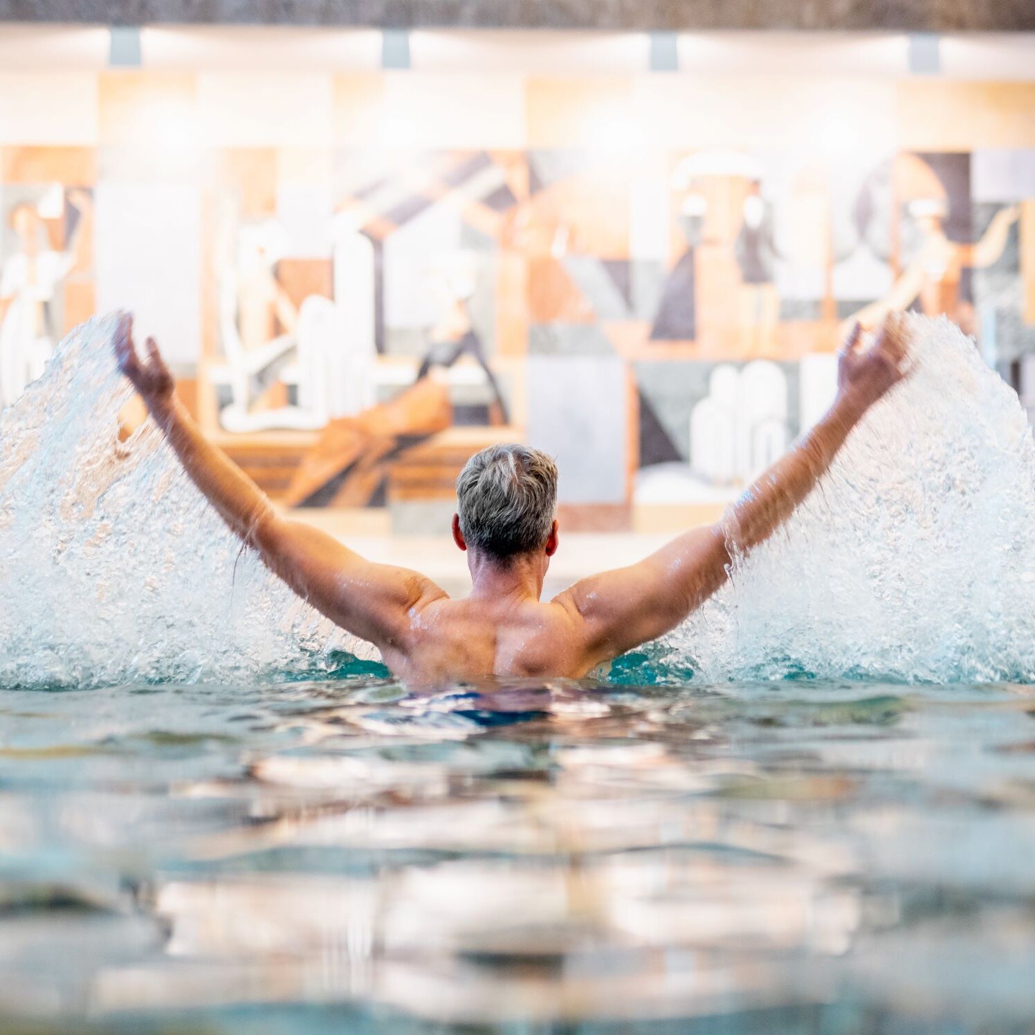 Mann badet im Uquellbecken der Therme Villach